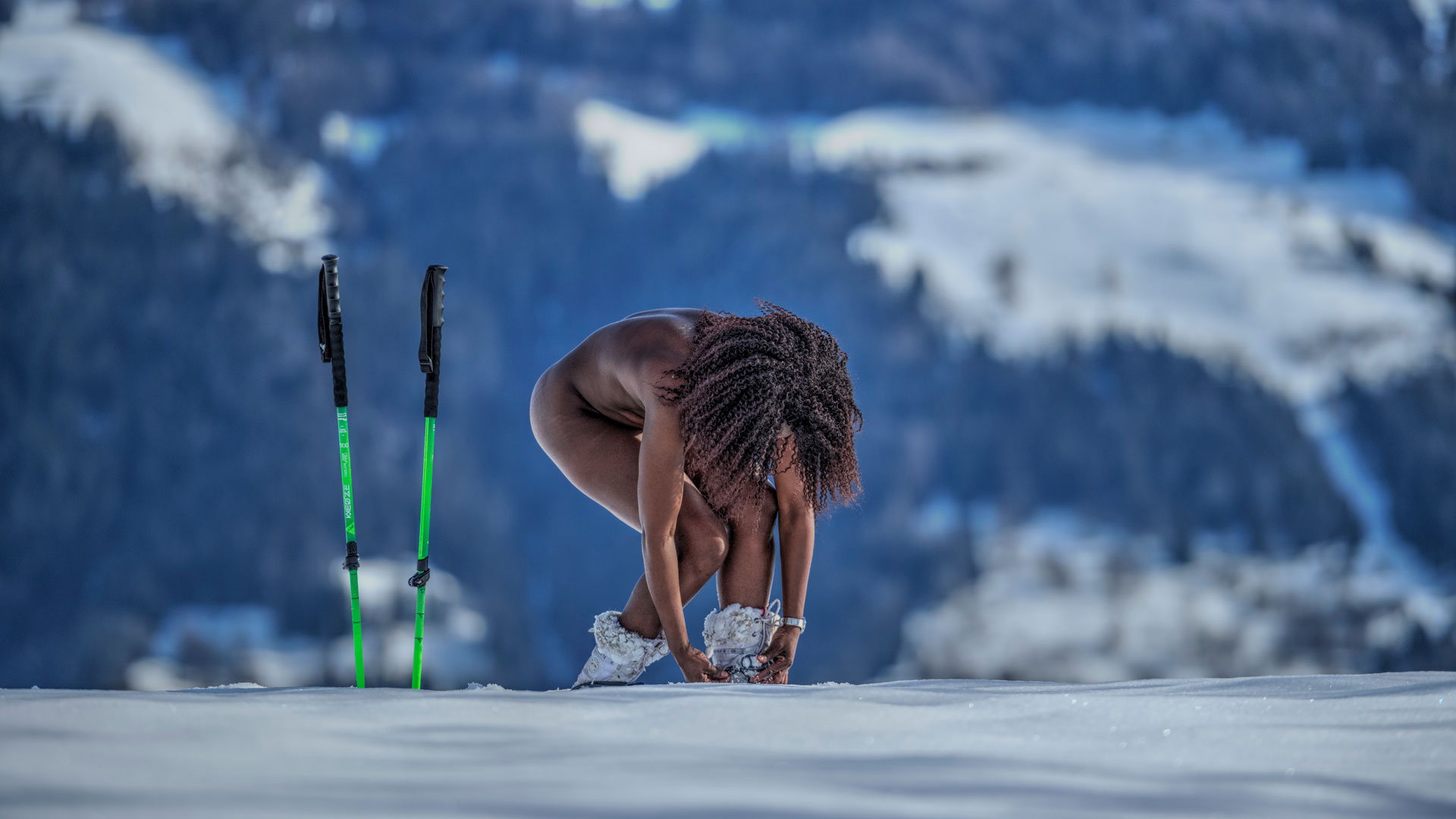 Femme nue attachant ses raquettes à neige