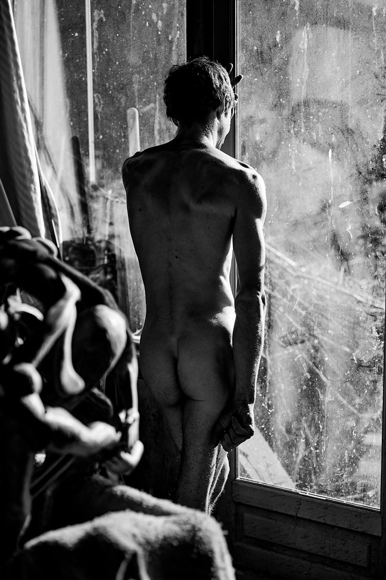 Homme nu en reflet sur une fenêtre