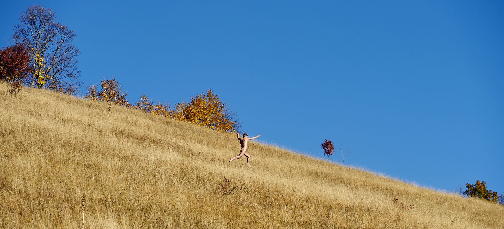 Homme nu courant dans les herbes jaune de l'automne